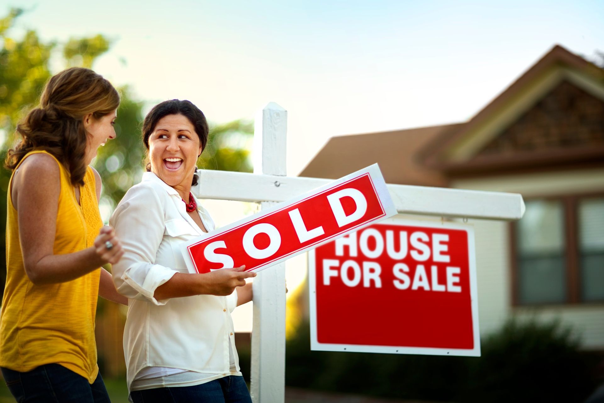 Couple celebrating with champagne with their real estate agent.